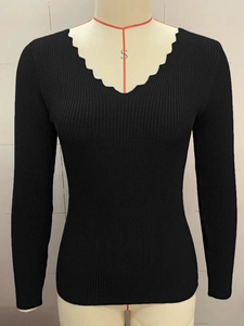 Close-up of black V-neck knit sweater with scalloped neckline and ribbed texture