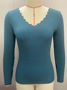 Close-up of slim fit V-neck knit sweater featuring ribbed texture and scallop trim