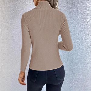 Detail view of the vertical ribbed texture and high neck design of this beige sweater