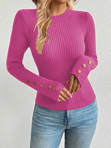 Detail of the golden buttons on magenta ribbed knit sweater sleeves for women