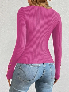 Detail of rose pink ribbed knit sweater featuring elegant gold button cuffs on sleeves