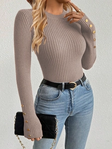 Close-up of taupe ribbed knit sweater featuring elegant gold button cuffs detail