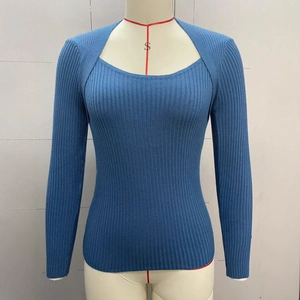 Dettaglio del maglione a coste azzurro con scollo quadrato e spalla a strati
