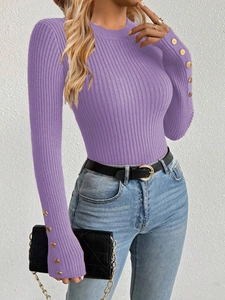 Close-up detail of golden buttons on purple ribbed knit long sleeve sweater