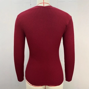 Dettaglio del maglione in maglia a coste rosso scuro con maniche lunghe e trama strutturata