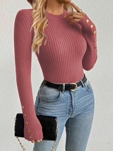 Detailed view of dust pink knit sweater with gold button accents on sleeves
