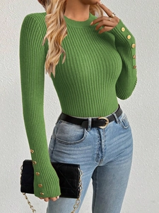 Detailed close-up of gold buttons on the sleeve cuffs of this green knit pullover