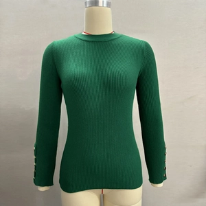 Close-up of fine ribbed knit fabric and gold decorative buttons on the sleeve cuffs