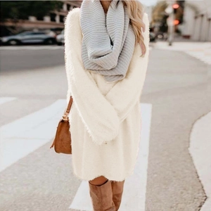 Detail of plush cream white sweater dress paired with grey striped scarf and leather bag