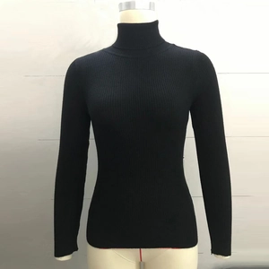 Close-up of black turtleneck knit sweater showing fine ribbed texture and slim fit design