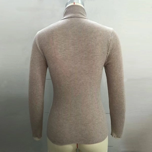 Close-up of beige high-neck sweater showing the vertical ribbed knit texture and slim fit
