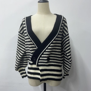 Détail d'un cardigan rayé en maille avec texture ondulée et boutons noirs de face