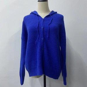 Detail of blue cable knit hooded cardigan showing thick texture and button closure