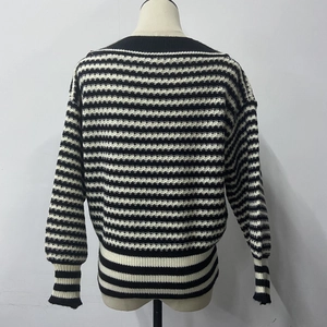 Vue détaillée du pull en tricot à rayures horizontales noires et blanches avec poignets côtelés