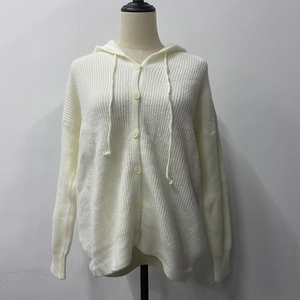 Detail of white knit hooded cardigan featuring matching buttons and textured fabric