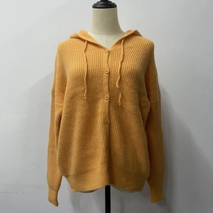 Detail of ginger knit cardigan showing ribbed cuffs and tonal resin buttons on a mannequin