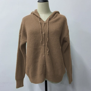 Detail of a brown knitted hooded cardigan with buttons and soft textured fabric