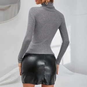 Detail of ribbed texture on gray turtleneck sweater paired with glossy leather skirt