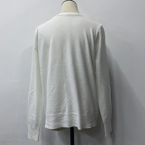 Back view of a white knit cardigan featuring premium ribbed cuffs and hem texture