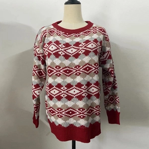 Détail du pull de Noël rouge avec motifs à losanges et finitions à bords-côtes
