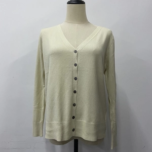 Detail of beige button-up cardigan featuring V-neckline and ribbed cuffs on a mannequin