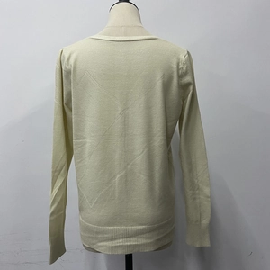 Rear view of cream knit sweater showing ribbed hem and cuff detail on mannequin