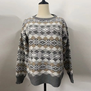 Vue détaillée du motif à losanges classique et des poignets côtelés sur le pull