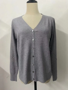 Detail view of grey V-neck knit cardigan featuring dark buttons and ribbed cuffs