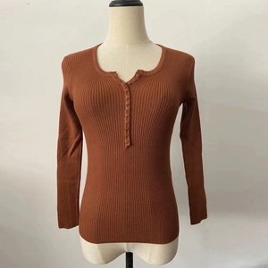 Close-up of caramel ribbed knit sweater featuring V-neckline with decorative buttons