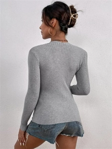 Close-up of grey long sleeve knit sweater with ribbed texture and square neckline