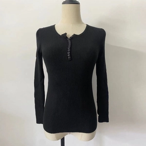 Close-up of black ribbed knit sweater featuring a functional buttoned Henley V-neckline