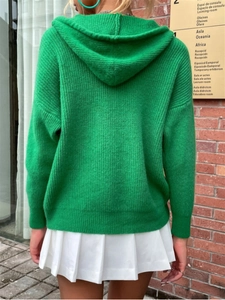 Detail of a bright green hooded knit cardigan featuring vertical ribbed texture