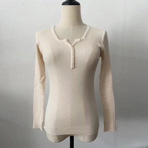 Detailed close-up of cream white ribbed knit sweater featuring buttoned V-neck collar detail