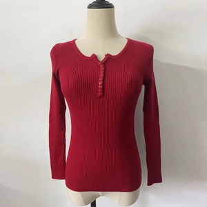Detailed view of dark red knit sweater featuring vertical ribbing and buttoned V-neckline