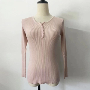 Detailed view of pink rib-knit sweater featuring a Henley neck and fabric-covered buttons