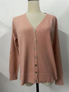Detail of pink V-neck knit cardigan with button closure and ribbed texture finish