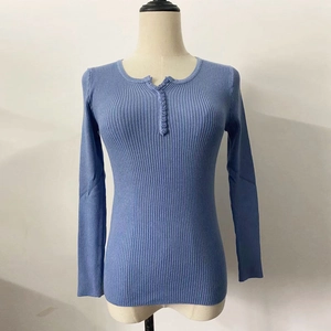 Close-up of ribbed knit texture on long sleeve blue Henley sweater with button detail