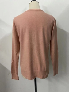 Detailed back view of a soft dusty pink knit cardigan with wide ribbed hem and cuffs