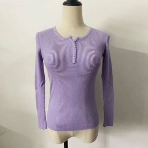 Detail of purple ribbed knit sweater showing the buttoned V-neckline and textured long sleeves