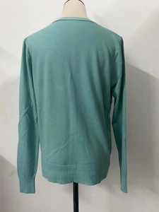Back view of mint green knit cardigan featuring ribbed cuffs and hem on mannequin