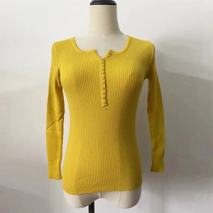 Detail of yellow ribbed knit sweater showing buttoned neckline and textured fabric surface