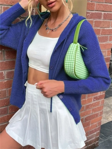 Detail of blue knit cardigan featuring vertical ribbed texture and matching buttons
