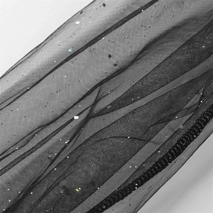 Detailed view of black mesh fabric with shimmering silver sequins on the evening dress