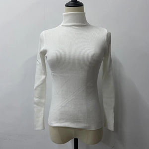 Detailed view of the white ribbed knit texture and turtleneck design on a slim fit top