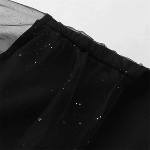 Macro view of black mesh dress featuring shimmering silver sequins and detailed seam work