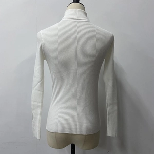 Close-up of white ribbed knit turtleneck sweater showing back texture and fitted design