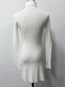 Detailed view of white ribbed knit dress featuring a turtleneck and slim fit texture