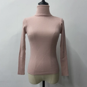 Close-up of pink ribbed knit high neck sweater featuring soft texture and slim fit