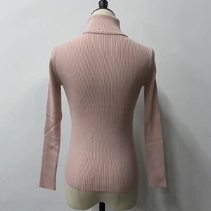 Detail of light pink turtleneck sweater showing vertical ribbed knit texture and slim fit