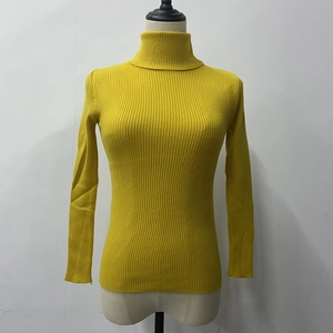 Detailed close-up of yellow ribbed knit turtleneck sweater with fine vertical texture